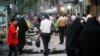 People strolling in the street in downtown of Tehran, undated.