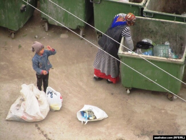 Женщина и мальчик собирают пластиковые бутылки в Ашхабаде. 16 января 2014 года