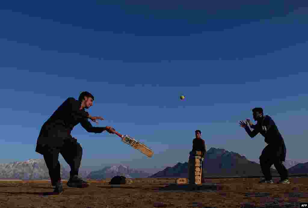 Afghan youths play cricket in a field on the outskirts of Kabul. (AFP/Wakil Kohsar)