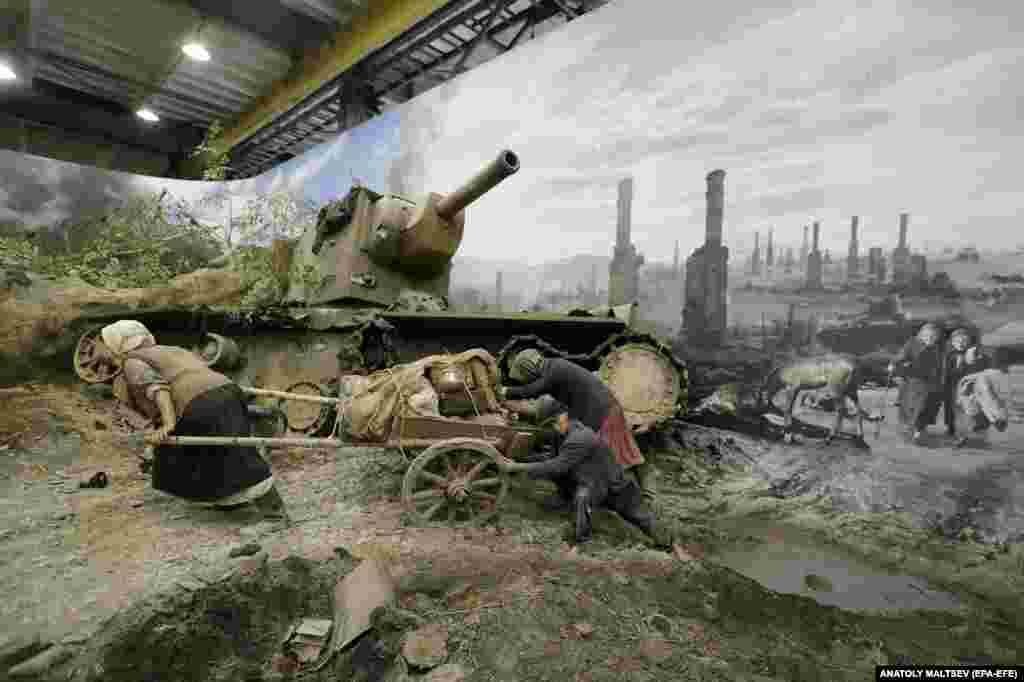 Refugees haul their belongings past a wrecked Soviet tank. These are some of the scenes from an exhibition recreating the battlefields of World War II, known in Russia as The Great Patriotic War.