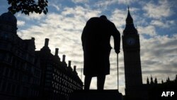 Statuia lui Winston Churchill în fața clădirii Parlamentului de la Londra, cu turnul Big Ben,