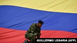 تصویر آرشیوی از سرباز کلمبیایی در کنار پرچم این کشور