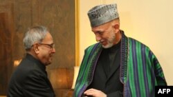 Indian President Pranab Mukherjee (left) greets his Afghan counterpart, Hamid Karzai, at the presidential palace in New Delhi.