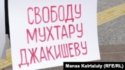 Түрмеде отырған Мұхтар Жәкішевке бостандық беру туралы талап жазылған плакат.