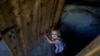 A girl leaves the bomb shelter in the Petrovskiy district. Some residents have lived in the basement dwelling for nearly a year.
