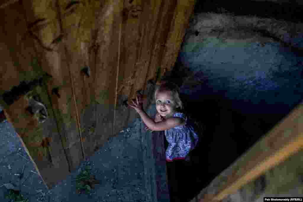 A girl leaves the bomb shelter in the Petrovskiy district. Some residents have lived in the basement dwelling for nearly a year.