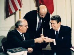 Washington/ 8 decembrie 1987. Președintele USA, Ronald Reagan și liderul sovietic, Mihail Gorbaciov făcând schimb de stilouri după semnarea Tratatului privind Rachetele cu Rază Medie de Acțiune, primul pas semnificativ spre sfârșitul Războiului Rece și reunificarea Europei