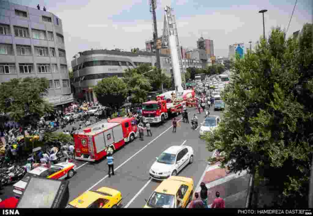 Crowds gather in Tehran&#39;s Haft-e Tir Square as emergency workers persuade the man to return to safety.