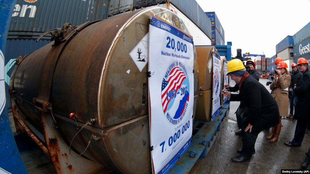Representatives of participating companies sign containers with uranium to be used as fuel for nuclear reactors, prior to loading them aboard a ship in St. Petersburg.