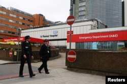 Doi ofițeri de poliție, staționați în fața spitalului Sfântul Thomas din Londra, la scurt timp după ce premierul Marii Britanii, Boris Johnson, a fost internat cu Covid, 6 aprilie 2020.