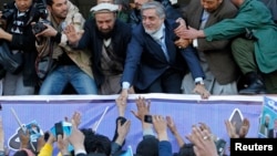 Presidential candidate Abdullah Abdullah shakes hands with his supporters during an election campaign in Kabul.