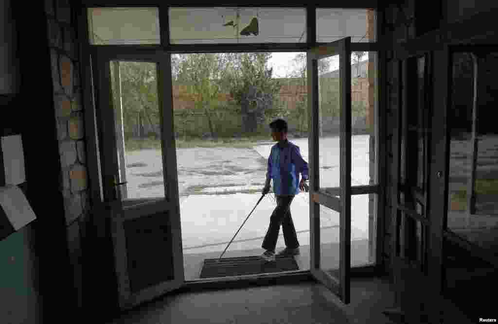 A blind student arrives for a lesson at the Kabul Blind School.