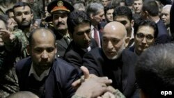 Afghan President Hamid Karzai (right) shakes hands with the Afghan soldiers during the ceremony opening the National Army Officer Academy outside Kabul on November 11..