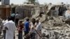 Iraqis stand amid the rubble of destroyed houses following a series of bomb attacks in the country on July 23. 