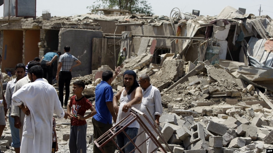 Iraqis stand amid the rubble of destroyed houses following a series of Al-Qaeda bomb attacks in the town of Taji, north of Baghdad which killed at least 42 people last month.