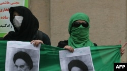 Iranian opposition supporters hold pictures of the late Ayatollah Ruhollah Khomeini during a protest at Tehran University, 13 December 2009
