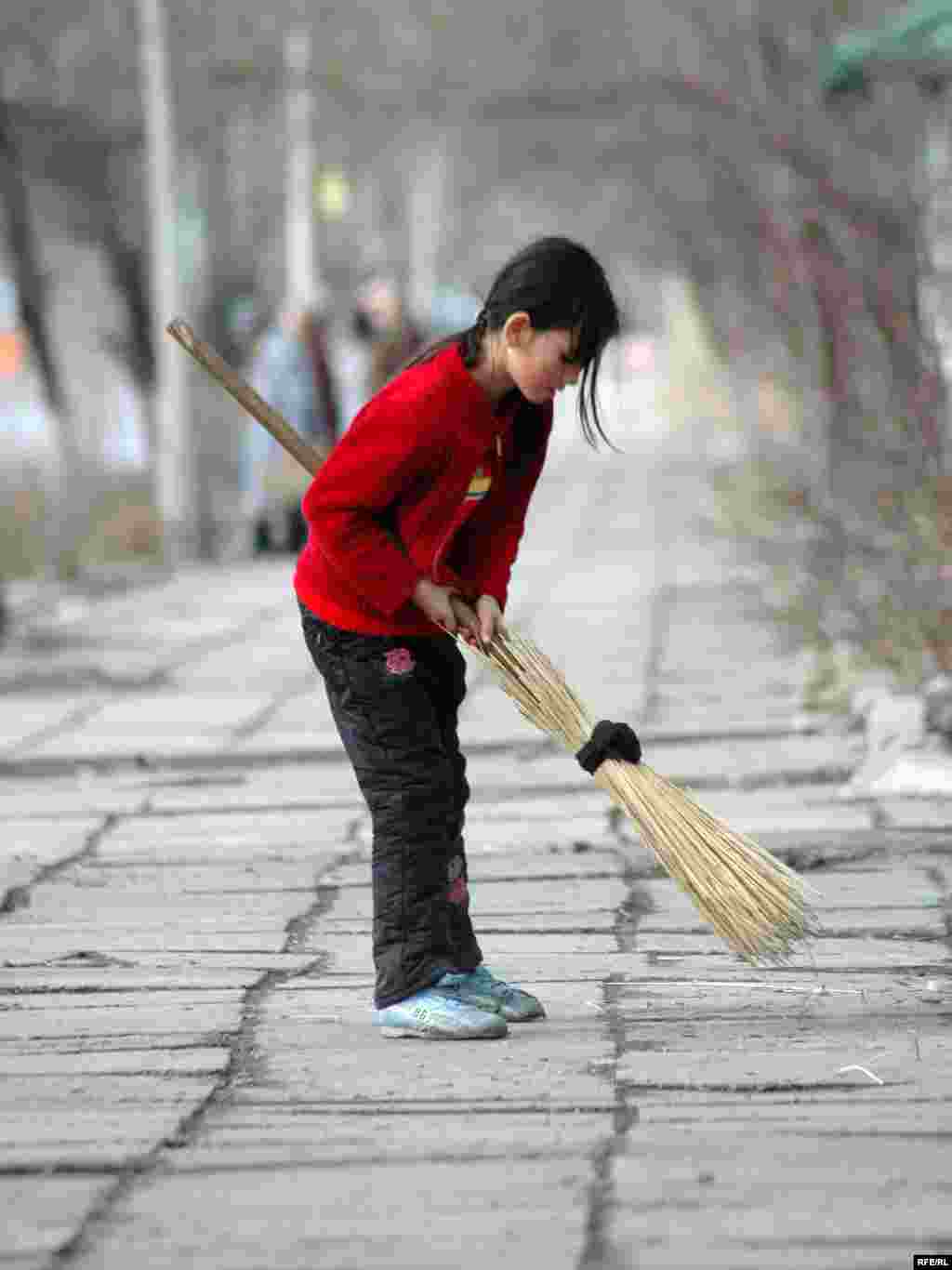 A girl sweeps sidewalks in Kyrgyzstan (RFE/RL) - Seventy percent of all working children -- some 132 million -- work in agriculture. Agriculture, together with construction and mining, is one of the three most hazardous sectors for workers of any age.