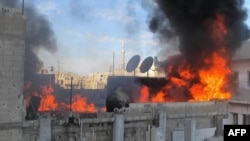 Syria -- Fire on the roof of a building in the Baba Amr neighborhoud of the flashpoint city of Homs, allegedly during the bombardment of the city, 22Feb2012