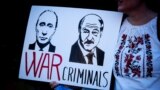 Изображения Владимира Путина и Александра Лукашенко с надписью "Военные преступники". Плакат на акции протеста против российского вторжения в Украину. Лондон, 26 марта 2022 года