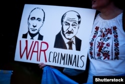 Плакат із зображенням президента Росії Володимира Путіна і Олександра Лукашенка з написом «Воєнні злочинці» на акції протесту проти російського вторгнення до України. Лондон, 26 березня 2022 року