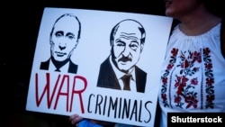 A poster depicts Russian President Vladimir Putin and Belarusian authoritarian leader Alyaksandr Lukashenka with the words "War Criminals" at a protest against Russia's invasion of Ukraine, in London in March 2022.