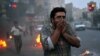 Protesters cover their faces from tear gas during clashes with riot police in Tehran on June 20