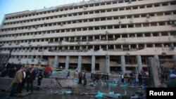 Люди собрались у поврежденного взрывом здания полицейского управления Каира. 24 января 2014 года.