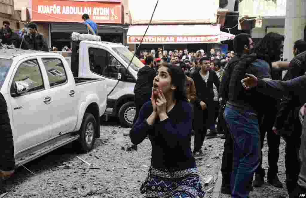 Türkiýe, Dirýarbekir şäheriniň merkezinde polisiýa edarasynyň ýanynda bolan güýçli partlama reaksiýa bildirýän aýal, 11-nji aprel. (AFP/Ilyas Akengin)