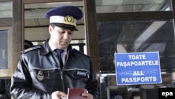 A Romanian customs officer checks a passport at the border with Moldova in Albita. The EU's eastern border divides the two neighbors.