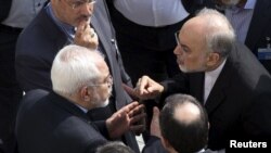 IIranian Foreign Minister Mohammad Javad Zarif (left) and head of the Atomic Energy Organization of Iran Ali Akbar Salehi (right) appear to have an intense discussion on the sidelines of negotiations with U.S. Secretary of State John Kerry over Tehran's nuclear program in Lausanne, Switzerland.