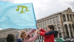 Дети держат в руках крымскотатарский флаг в центре Киева в честь Дня памяти о массовой депортации крымских татар в Центральную Азию и Сибирь в 1944 году. Украина, 18 мая (Сергей Нужненко)