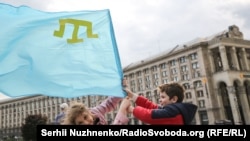 Copii care flutură un steag al tătarilor din Crimeea, în Kiev pe 18 martie când se marchează ziua de amintire a tătarilor din Crimeea care au fost deportați în Centrul Asiei și Siberia în 1944. Zeci de mii au murit în timpul deportărilor în masă, care au fost recunoscute de Ucraina drept un genocid. (Serhii Nuzhnenko, RFE/RL)