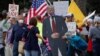 USA -- A cardboard cutout of U.S. President Donald Trump wearing a mask is brought to a protest over the stay-at-home orders involving the closing of beaches and walking paths during the outbreak of the coronavirus disease (COVID-19) in Encinitas, Califor