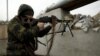 A militant fighting for Russia-backed separatist forces aims his weapon at a checkpoint at the front line with Ukrainian armed forces near the town of Avdiyivka, outside Donetsk, on March 17.