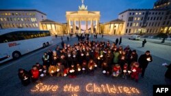 Demonstrators call for the international community to "Save the Children in Syria" and hold a minute of silence in front of the Brandenburg Gate in Berlin on March 14.
