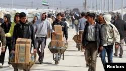 Сирийские беженцы в Иордане везут гуманитарную помощь, предоставленную из пожертвований западных стран