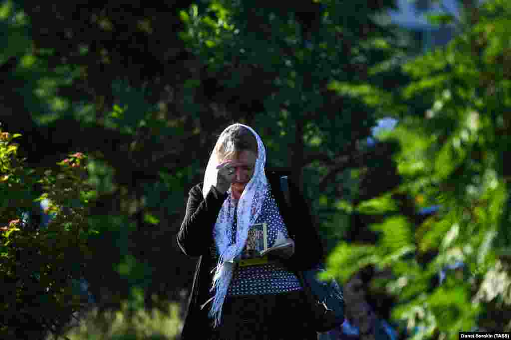 A woman pays her respects near the church at the site of the murders.&nbsp;