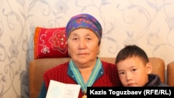 Житель Алматинской области 70-летняя мать-героиня Рахиля Иманкулова, мать заключенного Ерганата Тараншиева, с внуком. Микрорайон Шанырак-2 города Алматы, 22 октября 2016 года.