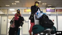  Пассажиры в масках прибывают из Лондона в аэропорт Белграда. 18 мая 2020 г.