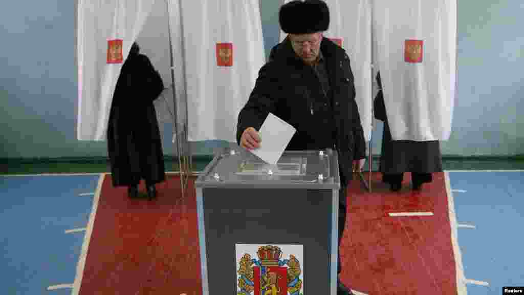 A man casts his vote in a polling station in the central Russian town of Divnogorsk.