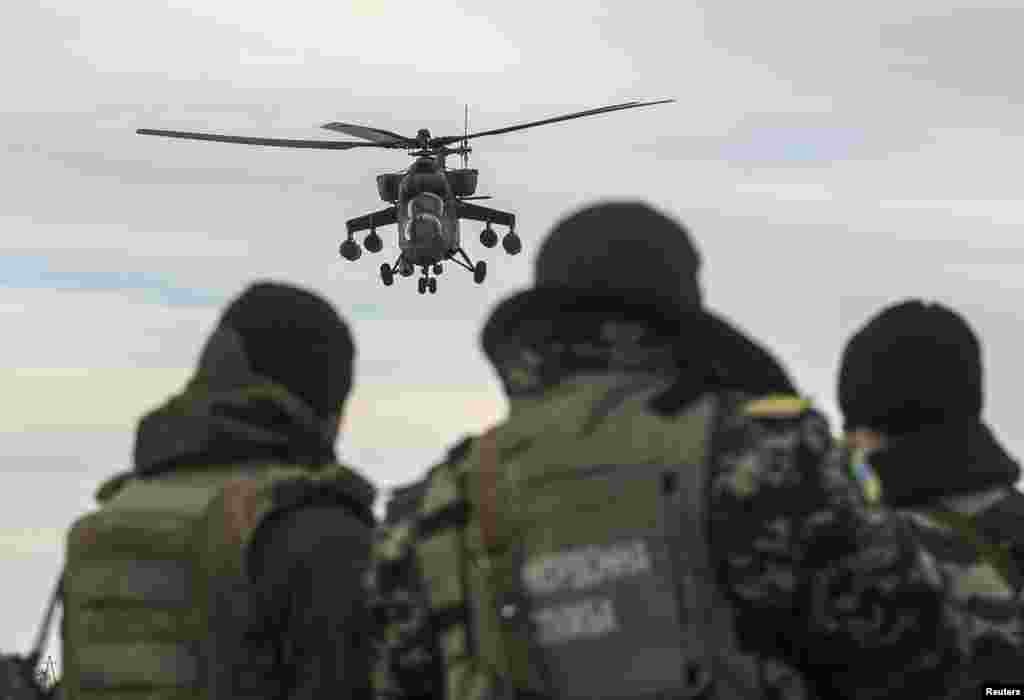 Українські прикордонники в Херсонській області спостерігають за російським військовим гелікоптером, 16 березня 2014 року