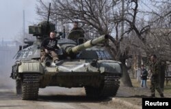 Members of the Ukrainian armed forces drive a tank in the settlement of Luhanske in the Donetsk region on March 27.