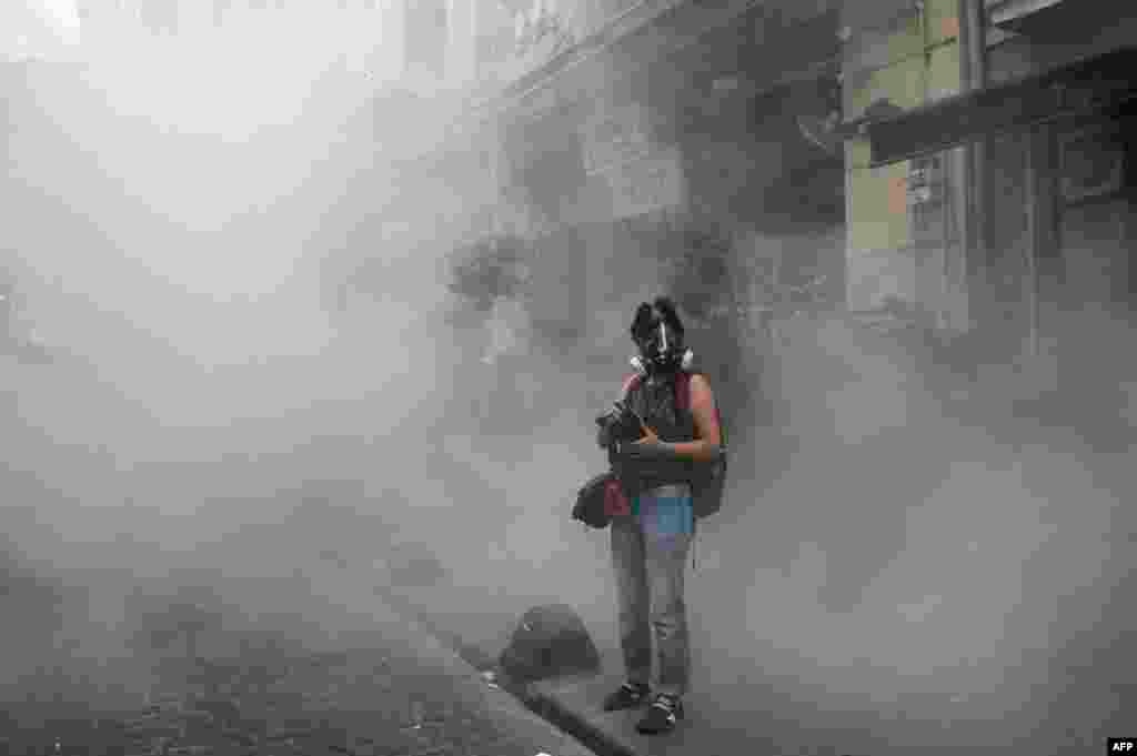 A journalist stands in tear gas as demonstrators staged a rally in support of the LGBT community on Istiklal Avenue in Istanbul. Riot police fired tear gas and rubber bullets to disperse protesters who defied a ban on the city's gay-pride parade. Authorities in Turkey's biggest city had banned the parade earlier this month, citing security reasons. (AFP/Ozan Kose)