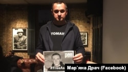 Олег Сенцов тримає плакат #FreeAseyev