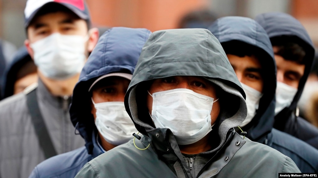 Migrant workers wearing protective face masks line up outside a migration control center to prolong their stay in Russia amid the ongoing coronavirus pandemic in St. Petersburg on April 3.