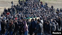 Crimean Tatars gather for the funeral of Reshat Ametov -- whose naked, bound, and apparently tortured body was discovered outside Simferopol -- on March 18.