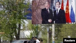 A billboard in southern Kyrgyzstan, where the ethnic violence has killed at least 170 people and injured many hundreds more, shows Russian President Dmitry Medvedev with the now-deposed Kyrgyz leader Kurmanbek Bakiev in April 2010.