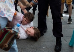 Инга Кудрачева кричит, ее молодой человек Борис Канторович пытается защитить ее от полиции, 27 июля 2019 года