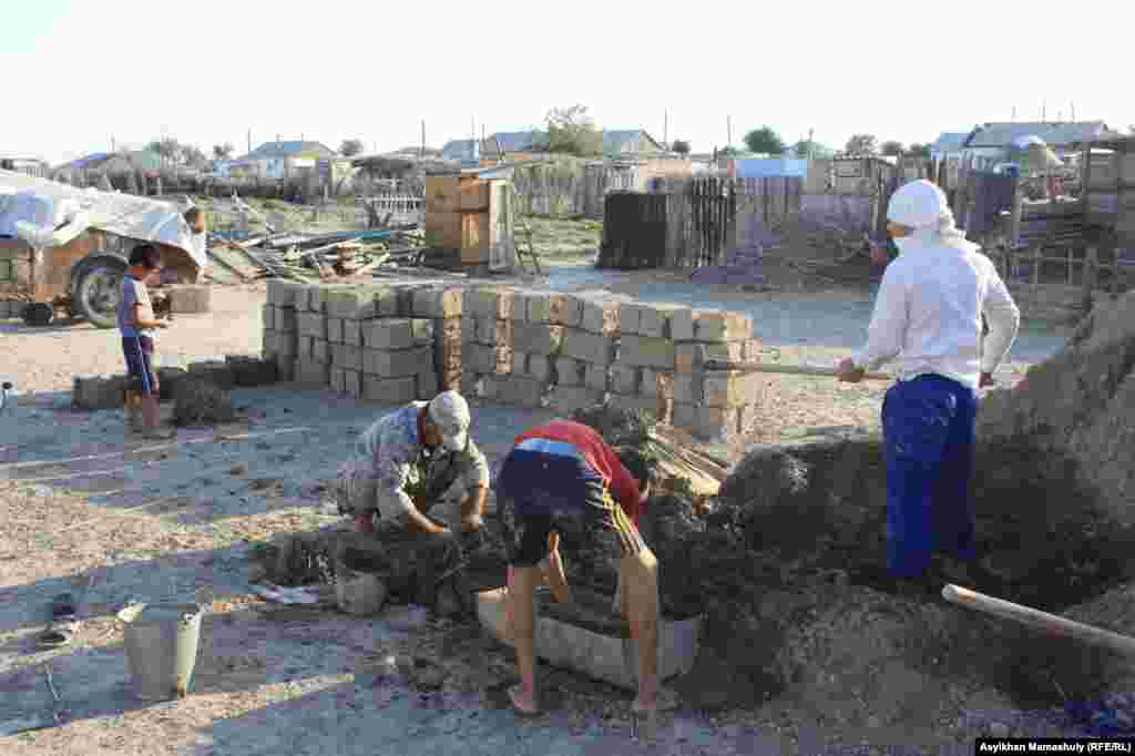 Жители села месят глино для прозводства кирпичей.