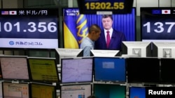 Трейдеры на фондовой бирже Токио смотрят выступление президента Украины Петра Порошенко